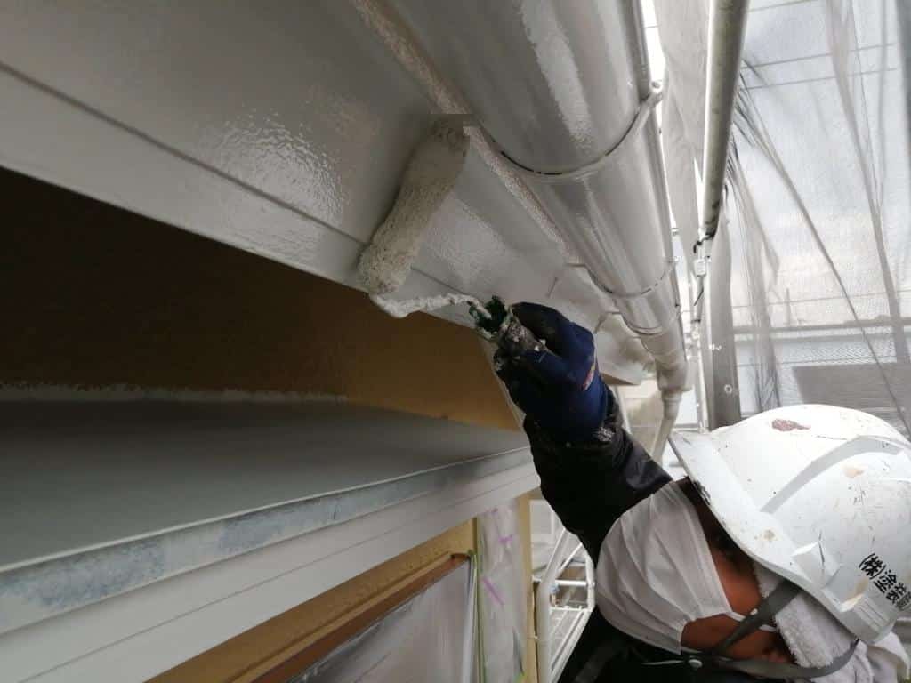 ローラーを片手に作業する菅職人
