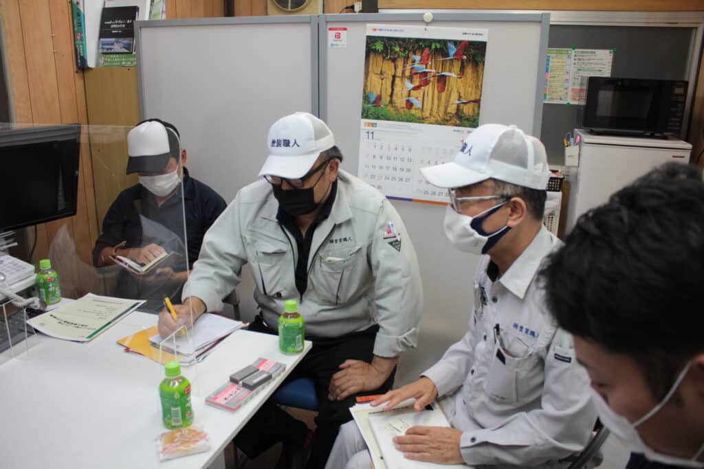 シール材メーカーの説明を受ける見積もり担当