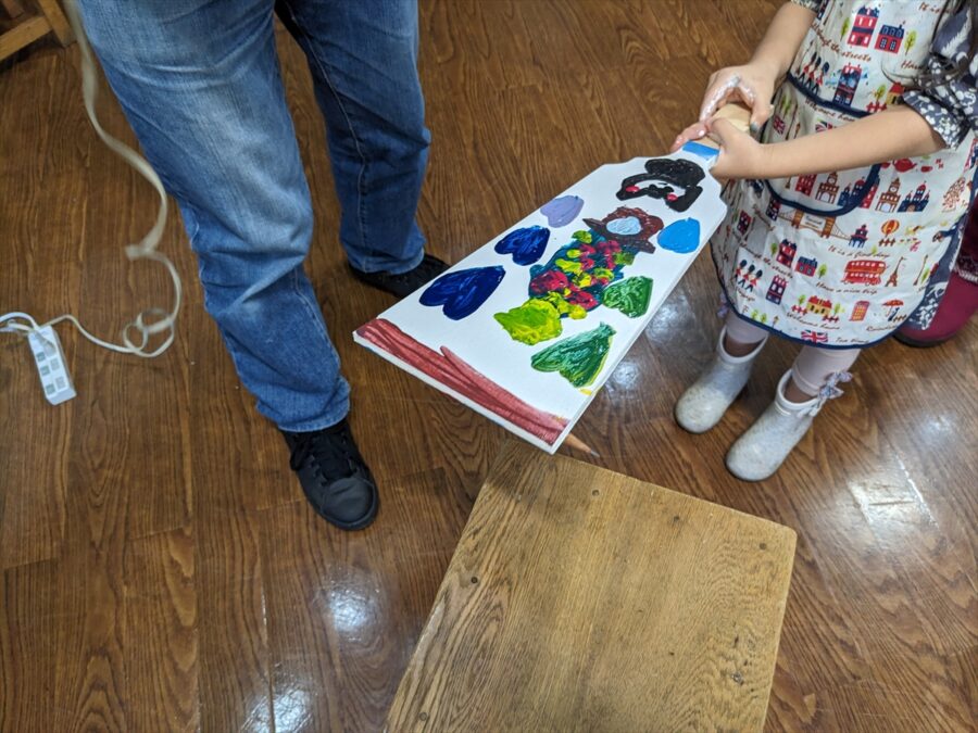 羽子板ペイントで作った作品を持つ子供