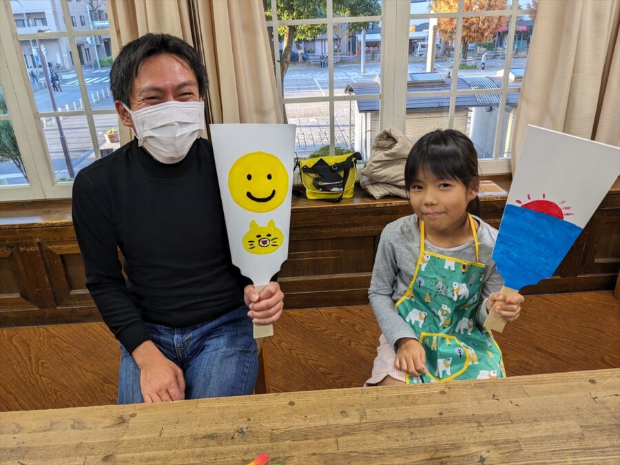 羽子板ペイントで作った作品を持つ親子