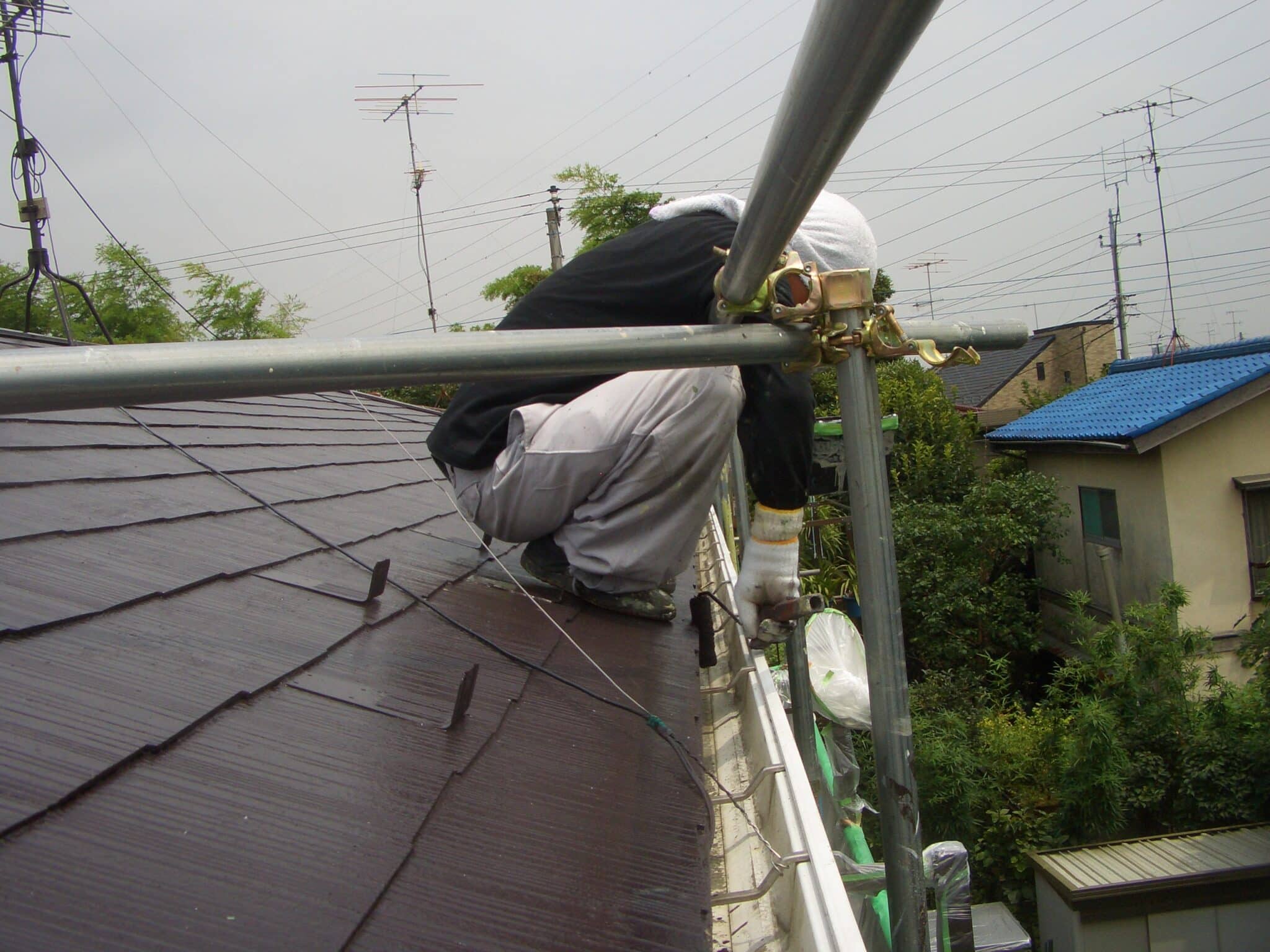 足場の鉢巻きの上の職人